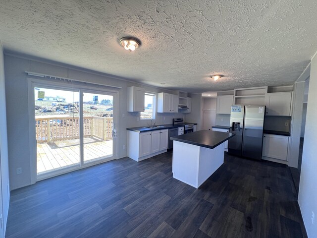 spare room with dark wood-style floors, visible vents, ornamental molding, and a textured ceiling