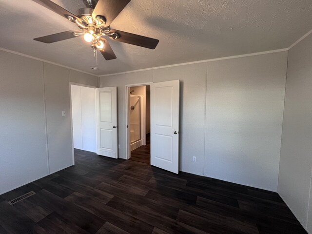 unfurnished room featuring ornamental molding, dark wood finished floors, and a textured ceiling