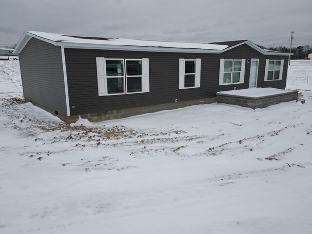 snow covered property with a garage