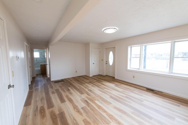 entryway with visible vents, light wood-style flooring, and baseboards