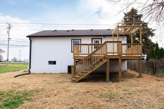 back of house with stairway, roof with shingles, a deck, and fence