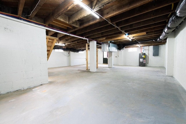 basement featuring electric panel and water heater