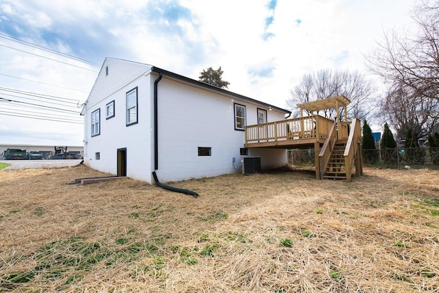 rear view of house with central air condition unit, stairway, a wooden deck, and fence