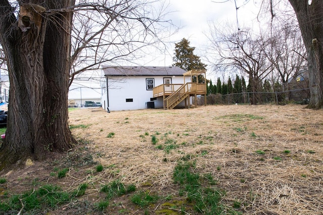 view of yard with a deck, stairway, and fence