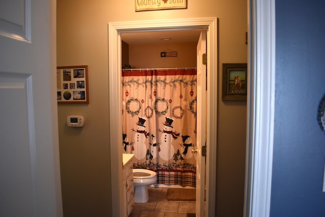 bathroom featuring toilet, vanity, tile patterned flooring, and walk in shower