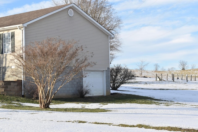 view of snowy exterior featuring a garage