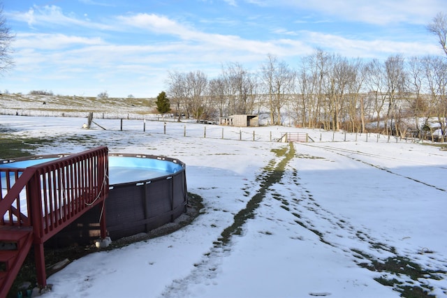 yard layered in snow with a swimming pool side deck