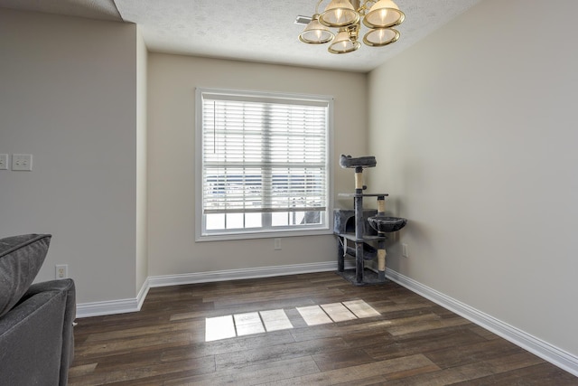 dining space featuring a textured ceiling, an inviting chandelier, and dark wood-type flooring