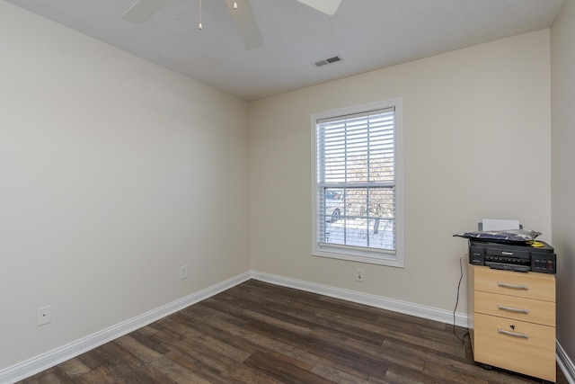 empty room with ceiling fan and dark wood-type flooring