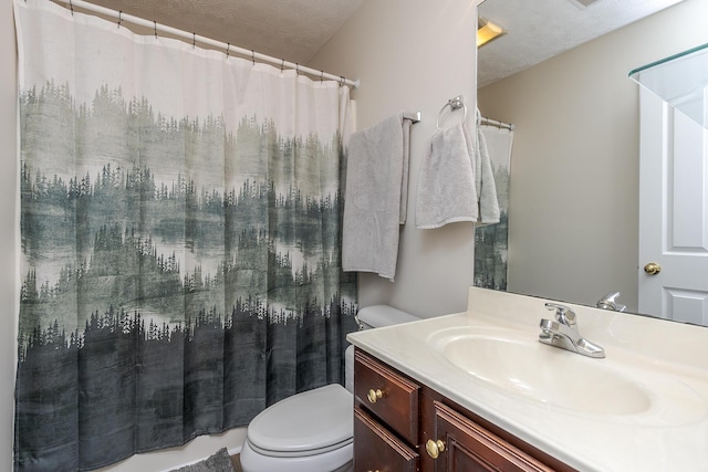 bathroom with toilet, vanity, and a textured ceiling