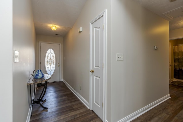 foyer entrance with dark wood-type flooring and a textured ceiling