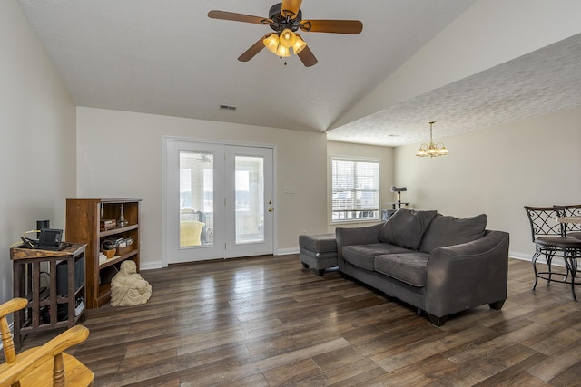 living room featuring ceiling fan with notable chandelier, dark wood-type flooring, and lofted ceiling