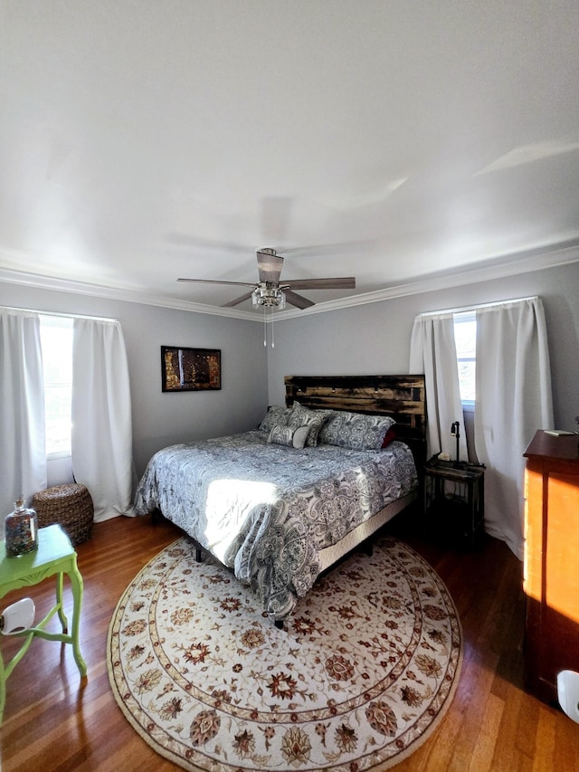 bedroom featuring crown molding, dark wood-type flooring, and ceiling fan