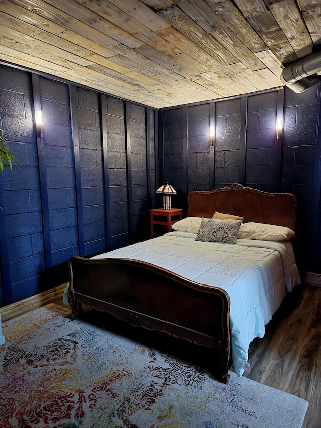 bedroom with wood ceiling and wood walls