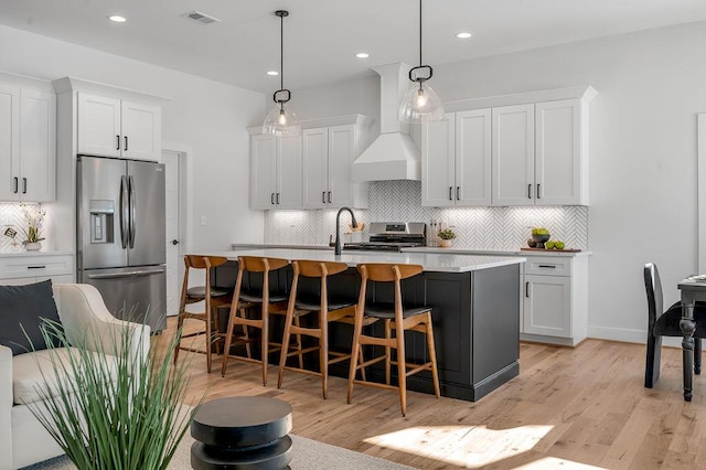 kitchen featuring white cabinets, appliances with stainless steel finishes, and pendant lighting