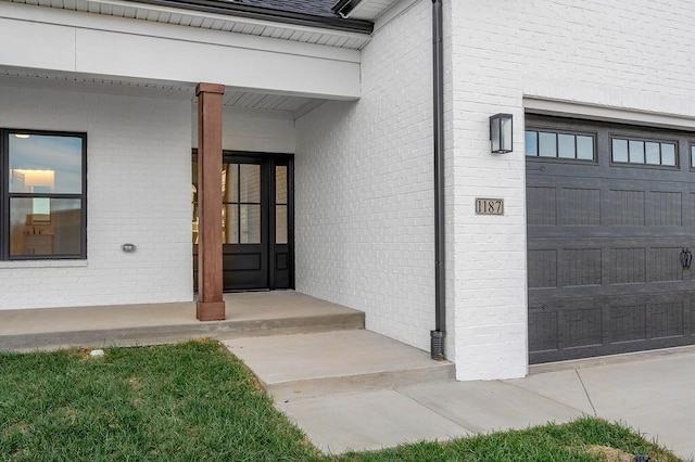 entrance to property with a garage and covered porch