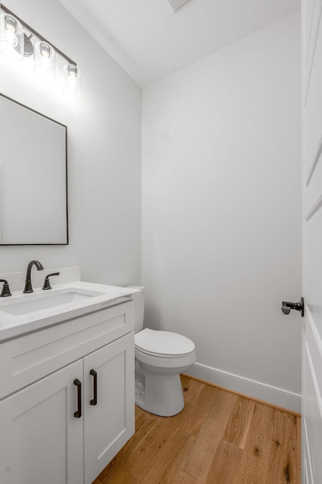 bathroom featuring hardwood / wood-style floors, toilet, and vanity