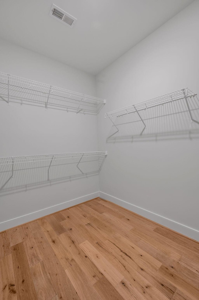 walk in closet with hardwood / wood-style flooring