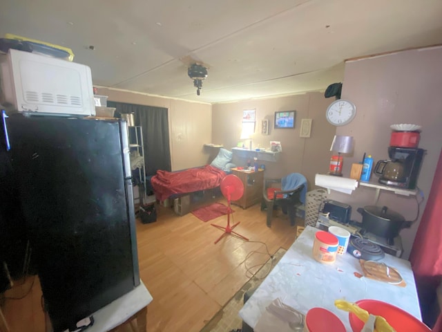 bedroom with light hardwood / wood-style floors and refrigerator