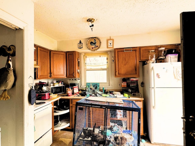 kitchen with white appliances and a textured ceiling