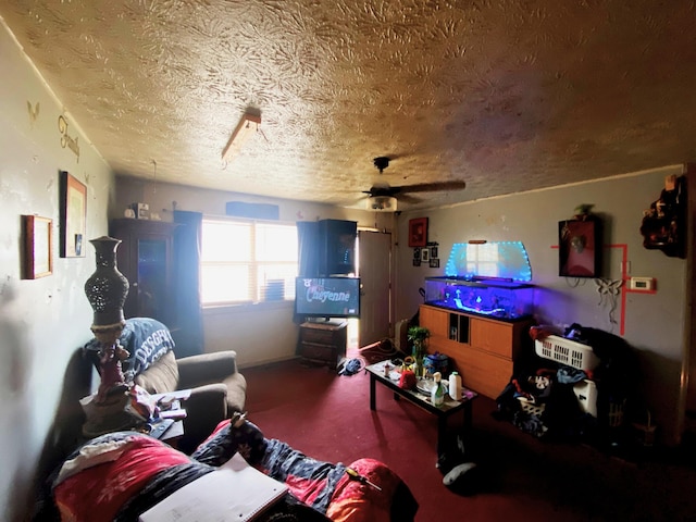 living room featuring ceiling fan and a textured ceiling