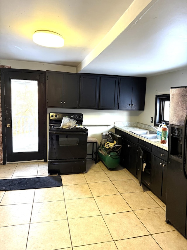 kitchen featuring a wealth of natural light, light tile patterned floors, sink, and black appliances