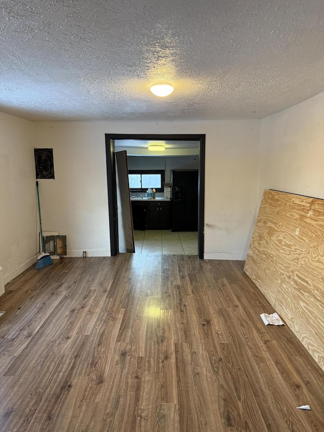 spare room with a textured ceiling and hardwood / wood-style flooring