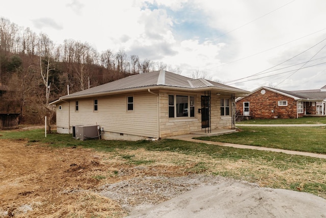 view of front of house with central AC unit and a front lawn