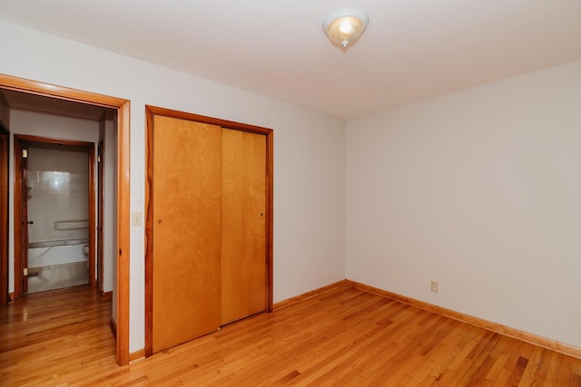 unfurnished bedroom featuring light hardwood / wood-style floors and a closet