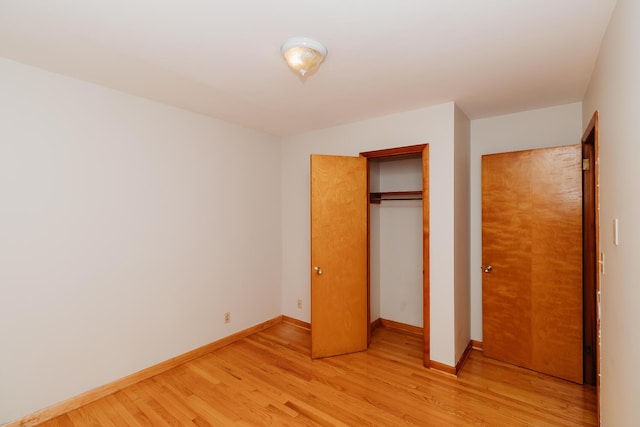 unfurnished bedroom featuring light hardwood / wood-style floors and a closet