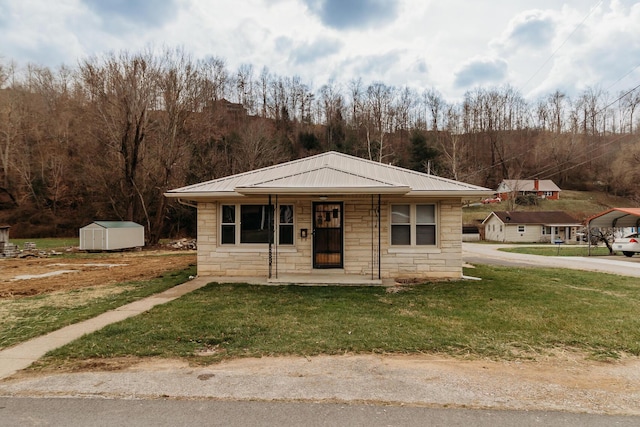 view of front facade with a storage shed, covered porch, and a front yard