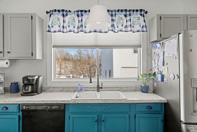 kitchen with sink, dishwasher, blue cabinets, and stainless steel fridge