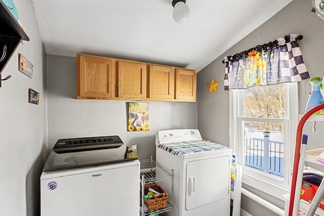 clothes washing area with washing machine and dryer and cabinets