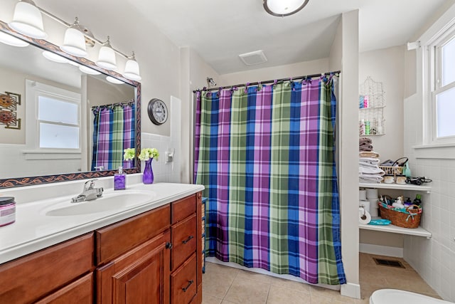 bathroom with toilet, tile walls, curtained shower, tile patterned flooring, and vanity