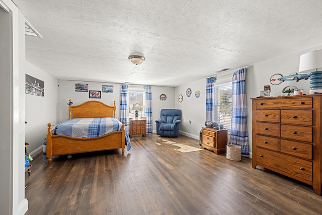 bedroom with a textured ceiling and dark hardwood / wood-style flooring