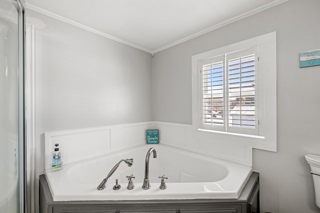 bathroom featuring toilet, ornamental molding, and a washtub