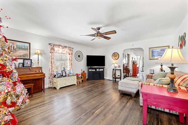 living room with ceiling fan and dark hardwood / wood-style flooring