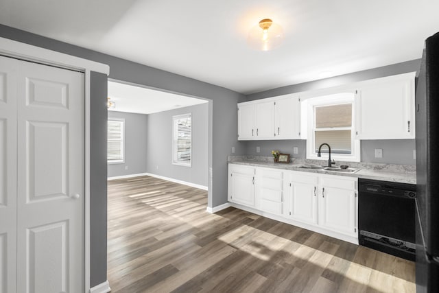 kitchen with white cabinetry, black dishwasher, dark hardwood / wood-style floors, light stone countertops, and sink