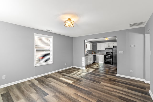 unfurnished living room featuring dark wood-type flooring and sink