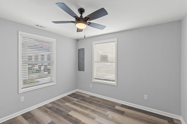 spare room with ceiling fan, hardwood / wood-style floors, and electric panel