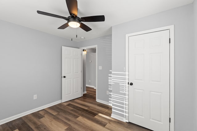 unfurnished bedroom featuring ceiling fan, dark hardwood / wood-style flooring, and a closet