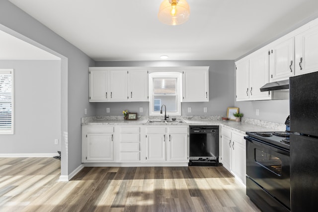 kitchen with hardwood / wood-style flooring, sink, white cabinets, and black appliances