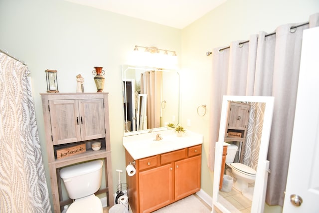 bathroom featuring toilet, tile patterned floors, and vanity