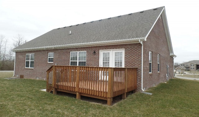 rear view of house featuring a wooden deck and a lawn