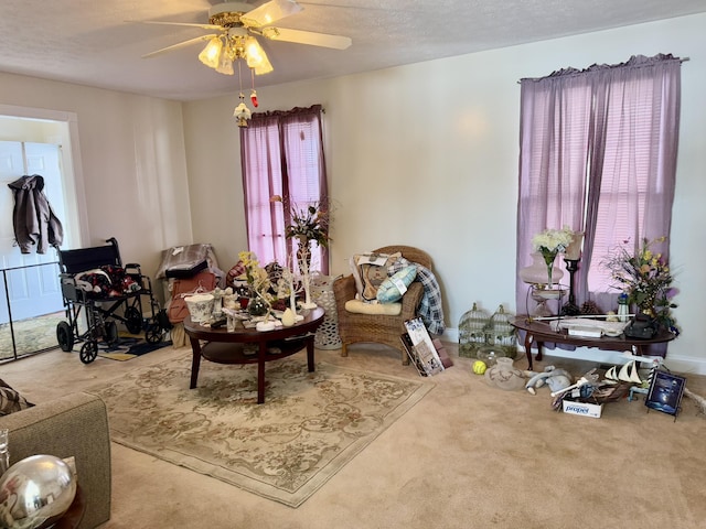 sitting room with a textured ceiling, ceiling fan, and carpet flooring