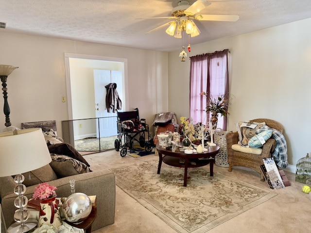 carpeted living room featuring a textured ceiling and ceiling fan