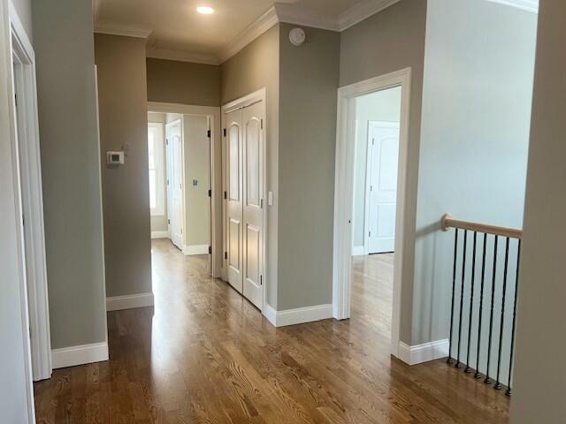 hallway with crown molding and hardwood / wood-style flooring