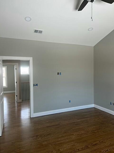 unfurnished room featuring ceiling fan, dark hardwood / wood-style flooring, and lofted ceiling