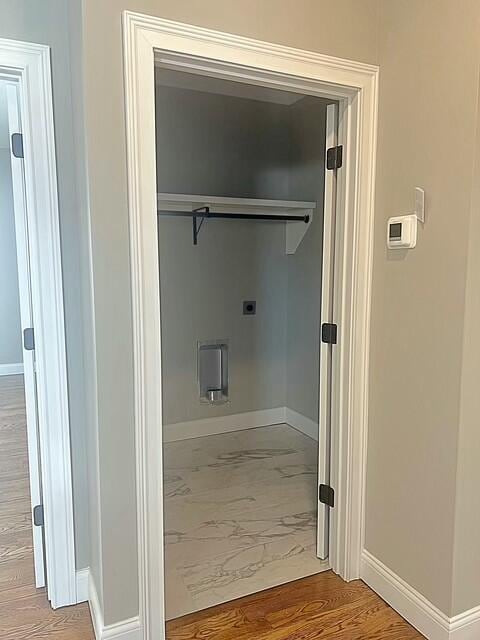 clothes washing area with hookup for an electric dryer and hardwood / wood-style flooring