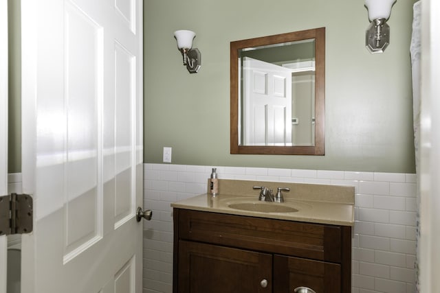 bathroom featuring vanity and tile walls